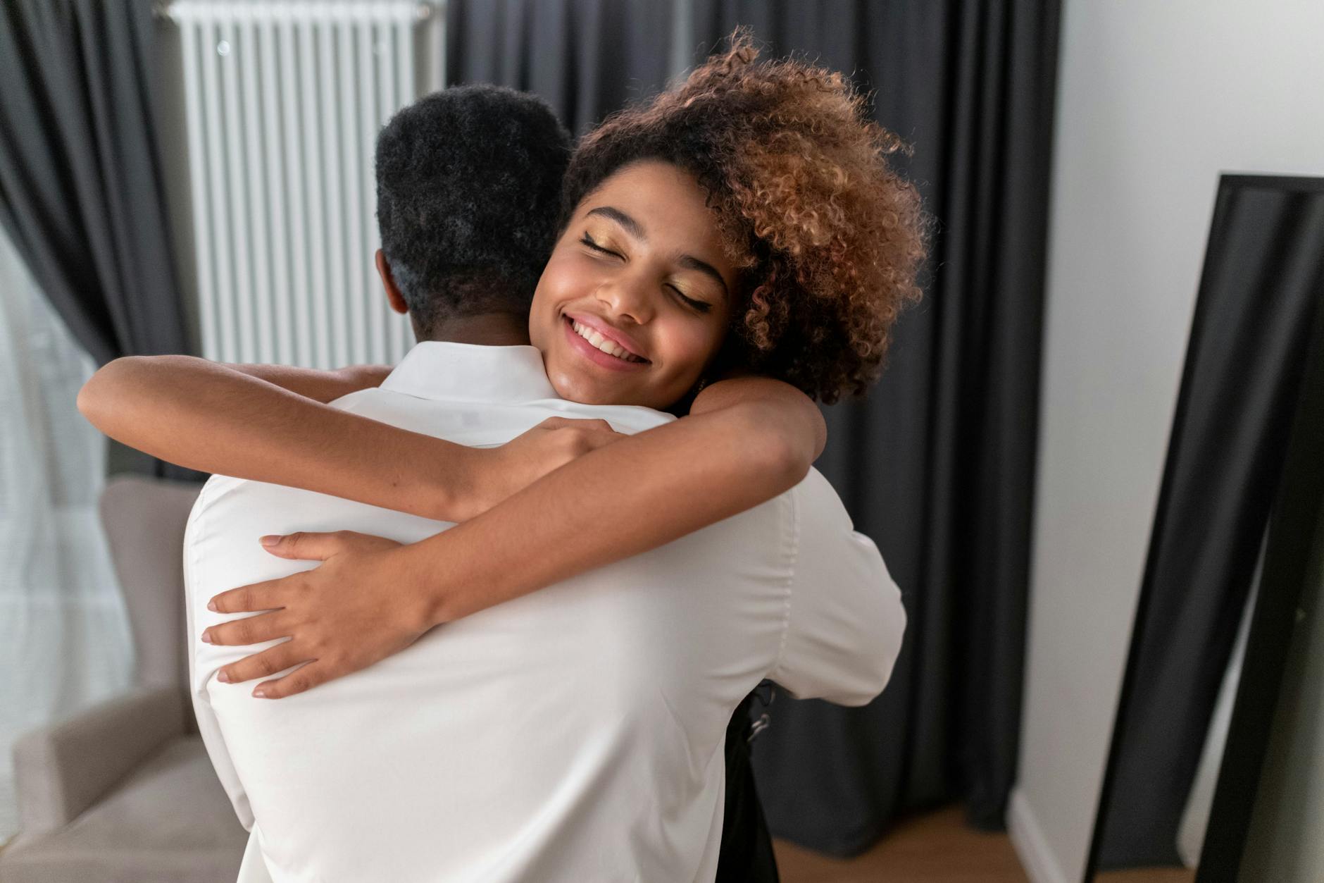 woman hugging a person in white long sleeve shirt
