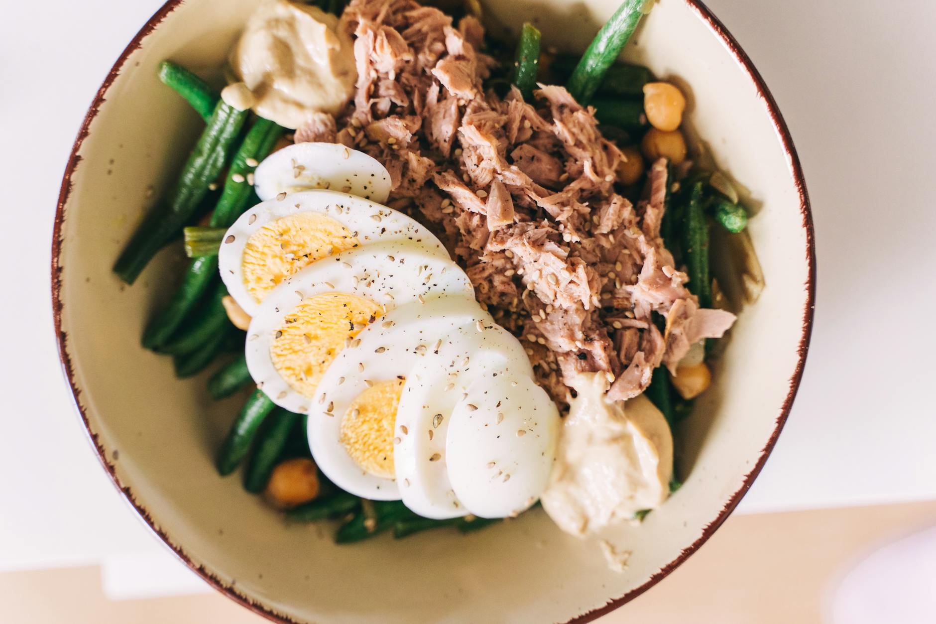 tuna and green beans with egg salad in ceramic bowl