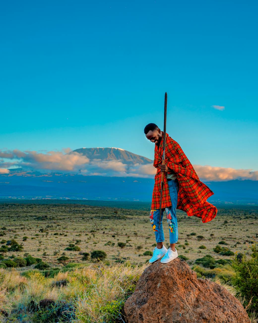 pexels-photo-8879241 man standing on a rock with a mountain in distance